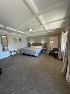 a large bedroom with a bed and a chair at BlueGem Motel in High Springs