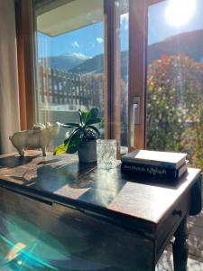 un tavolo con libri sopra una finestra di Villa Fleurettes STUDIO a Le Châble