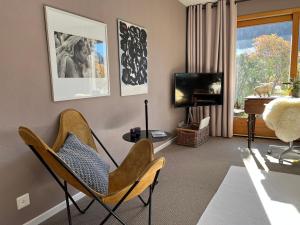 un soggiorno con 2 sedie e una TV di Villa Fleurettes STUDIO a Le Châble