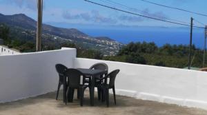una mesa negra y sillas sentadas en un balcón en Casa rural con Wifi, terraza y vistas al mar el La Palma, en Puntallana