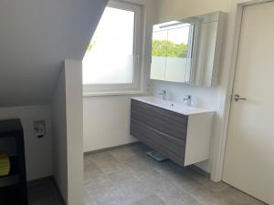 a bathroom with a sink and a window at Vakantie appartement in Luxemburg in Berbourg
