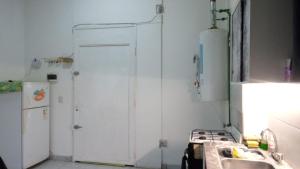 a kitchen with a white door and a sink and a refrigerator at Bless1 in Puerto Madryn