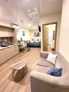 a living room with a couch and a kitchen at Alanta Apartments Easy Kaunas in Kaunas