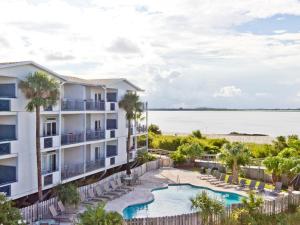 an apartment building with a swimming pool and a resort at Bay View Villas 105 in Tybee Island