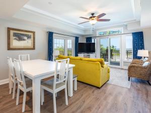 a living room with a table and a yellow couch at Bay View Villas 105 in Tybee Island