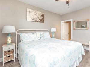 a bedroom with a large bed with a white bedspread at Bay View Villas 105 in Tybee Island