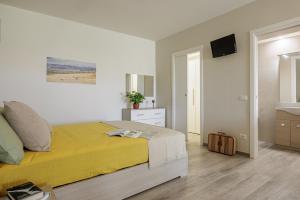 1 dormitorio con cama amarilla y lavamanos en Siena Living Apartment, en Siena