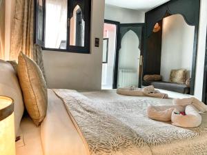 two beds with slippers on them in a bedroom at Riad 7 Pierres in Essaouira