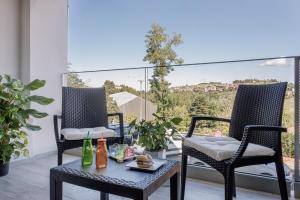 2 Stühle und ein Tisch auf einem Balkon mit Aussicht in der Unterkunft Siena Living Apartment in Siena