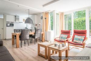 a living room with a table and a dining room at Residentie Californië in De Koog