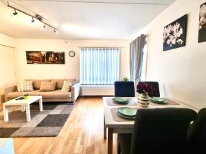 a living room with a couch and a table at Demims Apartments Lillestrøm - Central location & free parking -12mins from Oslo Airport in Lillestrøm