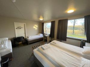 a hotel room with two beds and a window at Guesthouse Bitra B&B in Selfoss