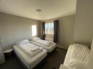 a hotel room with two beds and a window at Guesthouse Bitra B&B in Selfoss