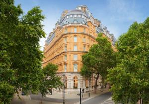 ein großes gelbes Gebäude mit einer Kuppel darüber in der Unterkunft Corinthia London in London