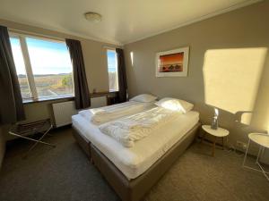 a bedroom with a bed and a large window at Guesthouse Bitra B&B in Selfoss