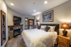 um quarto com uma cama grande e uma lareira em Best Ski in Out Location Next to Gondola, 2 Bedroom, C211 em Park City