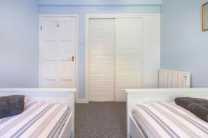 um quarto com duas camas e um armário em Cosy Modern Oxford Apartment em Oxford