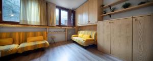 salon z 2 żółtymi krzesłami i oknem w obiekcie Condominio Escargot w mieście Breuil-Cervinia