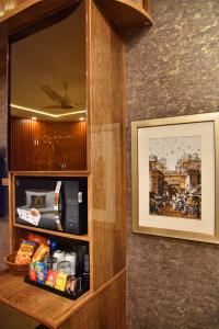 um armário com um micro-ondas e uma imagem na parede em Imperial Suites em Lahore