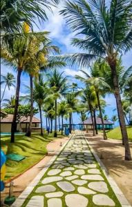 chodnik otoczony palmami na plaży w obiekcie Marulhos Suite Resort w mieście Porto de Galinhas