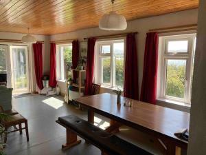 a living room with a wooden table and red curtains at Cosy Stay on The Wild Atlantic Way in Malin