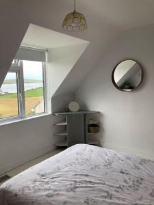 a bedroom with a bed and a mirror and a table at Cosy Stay on The Wild Atlantic Way in Malin
