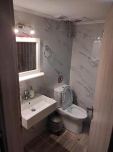 uma casa de banho com um WC branco e um lavatório. em Lakmos Studios em Ioannina