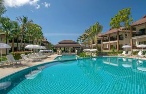 een zwembad in een resort met stoelen en parasols bij The Leaf Oceanside by Katathani - SHA Extra Plus in Khao Lak