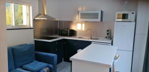 a small kitchen with a blue chair and a sink at GITE DOUSTRET in Argentat