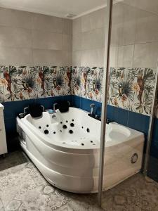 a white bath tub in a bathroom with a shower at Albatross in Kaunata