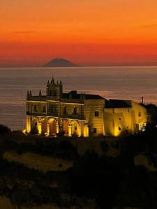 a house on the ocean with a sunset in the background at La Dolce Vita a Tropea in Tropea