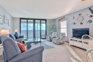 a living room with a couch and a tv and a table at Sand Dollar II 408 in Saint Augustine