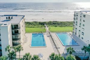 una vista panoramica su due piscine e sulla spiaggia di Sand Dollar II 408 a St. Augustine