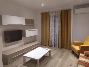 - un salon avec une télévision, un canapé et une table dans l'établissement Sliema Living, à Sliema
