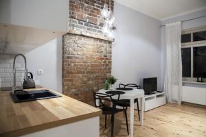 a kitchen with a table and a brick wall at Homewell Apartments Pod Szczerbatym in Poznań