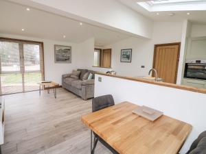 a kitchen and living room with a wooden table at 2 Meadow Retreat in Liskeard