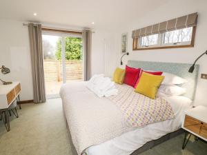 a bedroom with a bed and a desk and a window at 2 Meadow Retreat in Liskeard