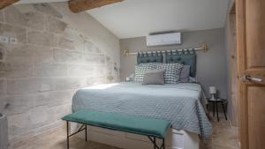 sypialnia z łóżkiem i kamienną ścianą w obiekcie Duplex calme et climatisé au Centre historique w Awinionie