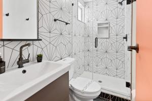 a bathroom with a white toilet and a shower at Urban Chic 1BR - Walk to Boardwalk - Min to Beach in Atlantic City