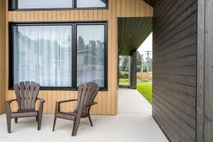 two chairs sitting on the porch of a house at Initial / Soeur No2 / MSA in Saint-Férréol-les-Neiges