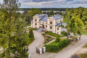 an aerial view of a large white house with trees at Pałac Warlity in Olsztynek