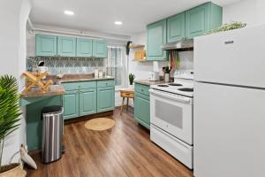 a kitchen with blue cabinets and a white refrigerator at Tropical Bohemian 1BR Apt near Atlantic City Beach in Atlantic City