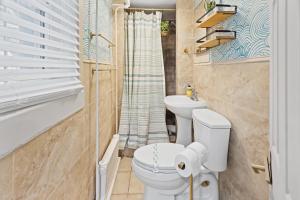 a bathroom with a toilet and a sink at Tropical Bohemian 1BR Apt near Atlantic City Beach in Atlantic City +9 photos