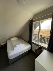 a small bedroom with a bed and a window at Guesthouse Bitra B&B in Selfoss