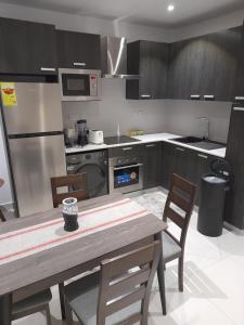 una cocina con mesa de madera y sillas. en The Lennox D-Plus Apartments, en Accra