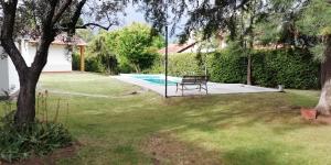 a swing in a yard with a pool at Casa en Chacras de Coria in Chacras de Coria