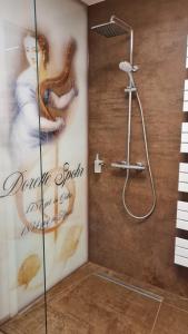 La salle de bains est pourvue d'une douche et d'une affiche murale. dans l'établissement Gästehaus Luise, à Gotha