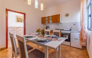 a kitchen with a table and chairs and a kitchen with a table and a kitchen at Cozy Apartment In Liznjan With Wifi in Ližnjan