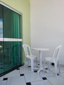 two white chairs and a table in a room at POUSADA PRAIAMAR in Prado