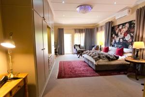 een slaapkamer met een bed en een woonkamer bij Ben's Bed and Breakfast in Pretoria